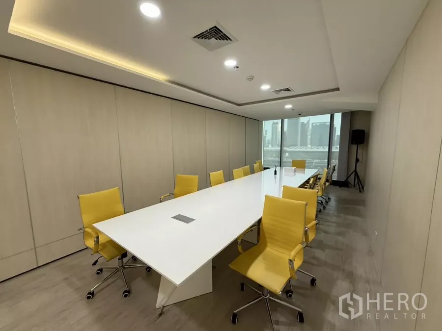 办公空间 出租在Din Daeng, Bangkok - 现代会议室，长形白色会议桌配黄色椅子，嵌灯天花与大窗城市景观。