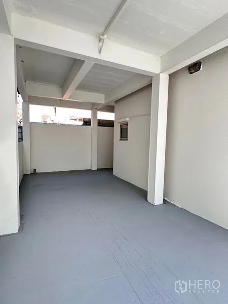 Home Office for sale in Lat Krabang, Bangkok - Deep covered garage space with concrete floor and support columns.