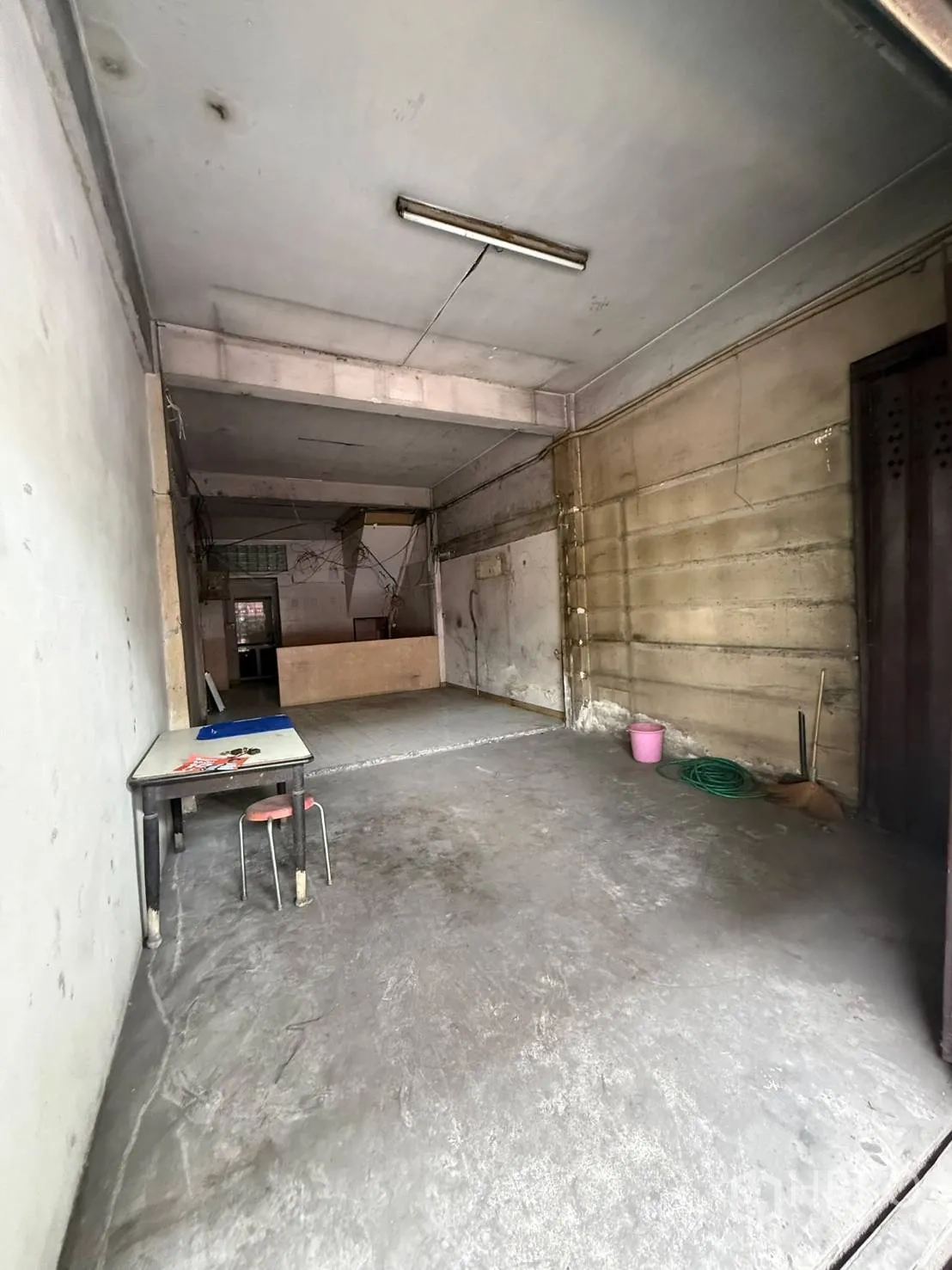 店屋 for rent in Khlong Toei, Bangkok - 底层开间空间，水泥地面与日光灯照明，配滑动金属门。