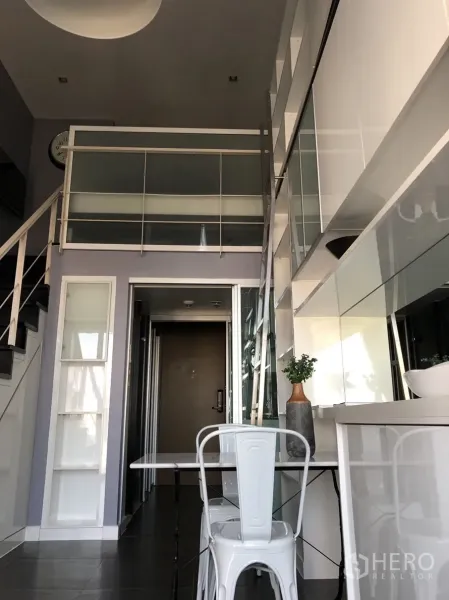 คอนโด ให้เช่าหรือขายในKhlong Toei, Bangkok - มุมจากทางเข้าเห็นราวชั้นลอย ตู้บิวท์อินเงามันพร้อมกระจก โต๊ะอาหารขนาดกะทัดรัด และผนังเก็บของแบบบันได