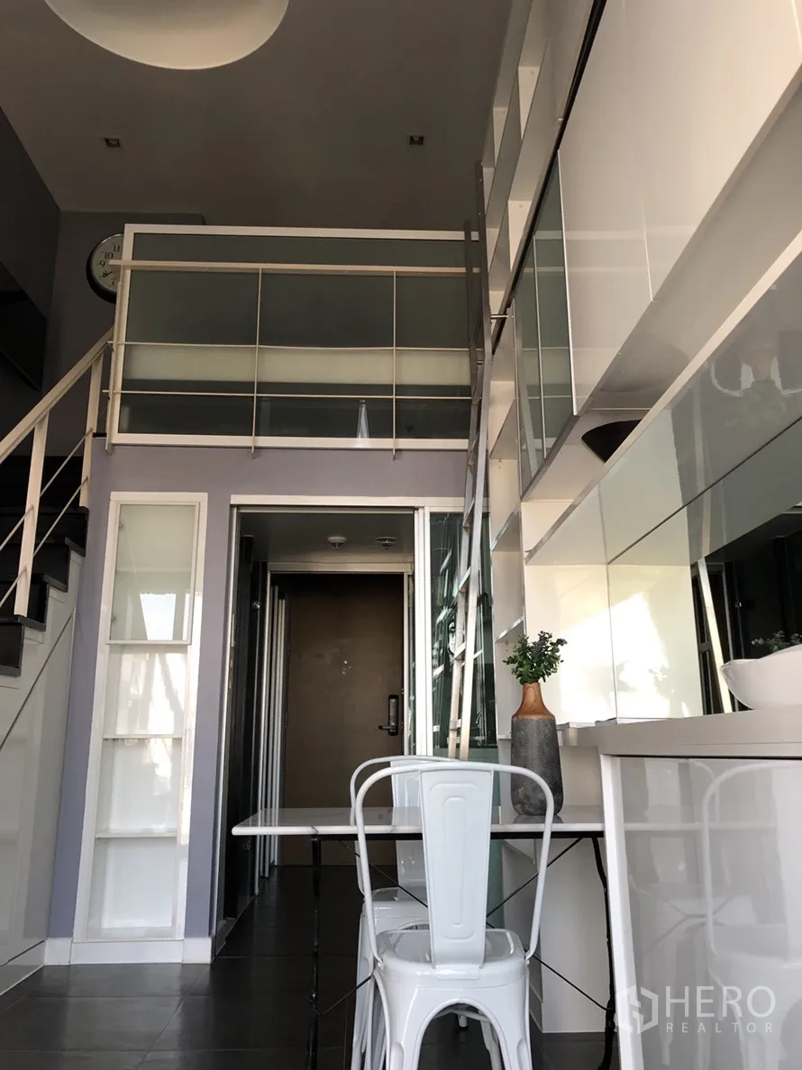 คอนโด ให้เช่าหรือขายในKhlong Toei, Bangkok - มุมจากทางเข้าเห็นราวชั้นลอย ตู้บิวท์อินเงามันพร้อมกระจก โต๊ะอาหารขนาดกะทัดรัด และผนังเก็บของแบบบันได