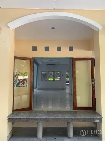 Detached House for rent in Khlong Toei, Bangkok - Arched entrance with double wooden doors opening to the bright living area.
