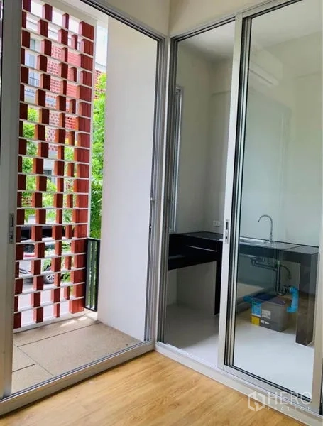 Home Office for rent - Compact pantry behind sliding glass with sink and small balcony screened by red breeze blocks.