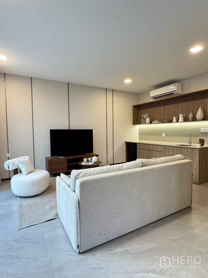 Detached House for rent in Saphan Sung, Bangkok - Family room with sofa, TV and a pantry with sink and wood cabinetry.
