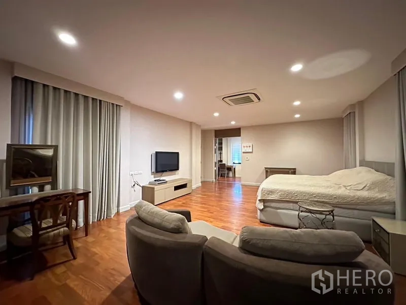 บ้าน ให้เช่าหรือขายในKhan Na Yao, Bangkok - มุมพักผ่อนในห้องนอนใหญ่ ตู้ทีวี เก้าอี้ และผ้าม่านสูง