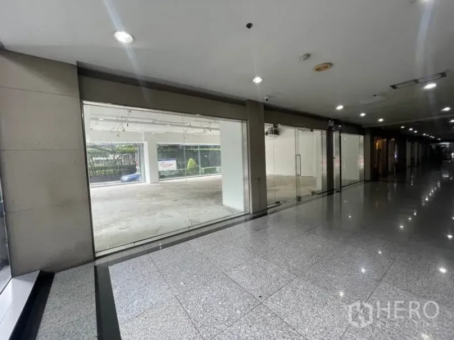 พื้นที่ขายปลีก ให้เช่าในWatthana, Bangkok - พื้นที่ค้าปลีกชั้นล่าง หน้าร้านกระจกเต็มบาน มองจากโถงอาคารพื้นแกรนิตเงา