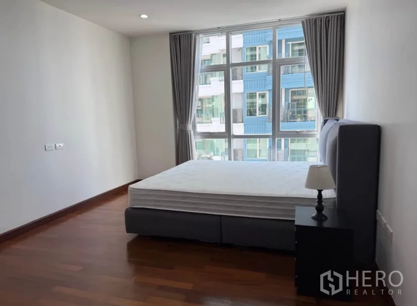คอนโด for rent in Pathum Wan, Bangkok - ห้องนอนสว่างพร้อมเตียง ผ้าม่าน และหน้าต่างบานใหญ่ พื้นไม้