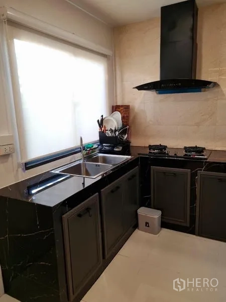 ทาวน์เฮาส์ ให้เช่า - ครัวรูปตัวแอล เคาน์เตอร์หินลาย พร้อมอ่างล้างจาน เตาแก๊ส และเครื่องดูดควัน
