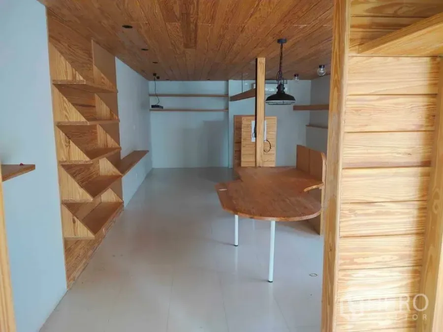 办公空间 出租在Khlong Toei, Bangkok - 办公室内景，之字形内置置物架，弧形桌，木天花与浅色地面。