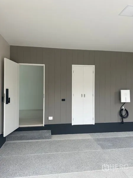 Detached House for rent in Bang Kapi, Bangkok - Covered carport with storage cabinet and EV charger point on the wall.