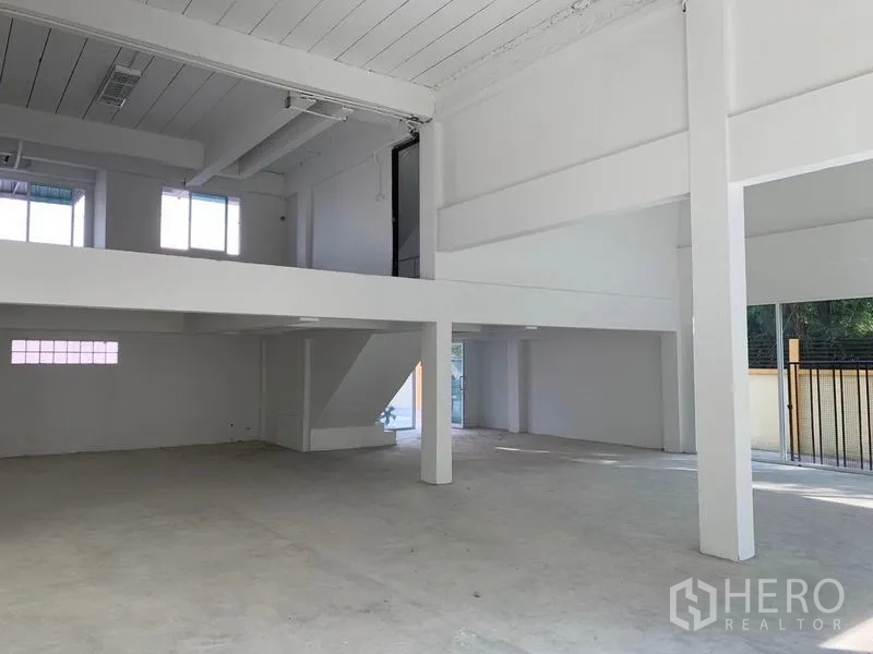 办公空间 出租在Huai Khwang, Bangkok - 一层挑高空间，设夹层与楼梯，靠近入口与围栏。