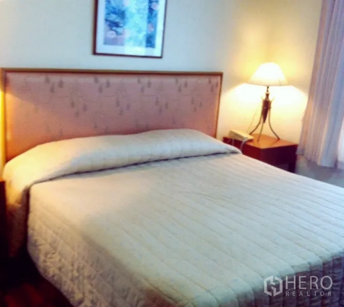 Condominium for rent in Watthana, Bangkok - Bedroom with a king bed, bedside lamp, and soft natural light.