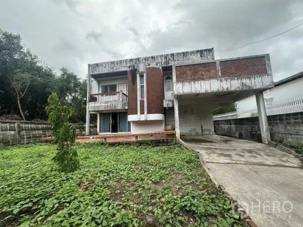 บ้าน ขายในPhra Khanong, Bangkok - มุมมองด้านหน้าบ้านเดี่ยว ทางรถยาว พร้อมเฉลียงยกระดับและสวนล้อมกำแพง ใกล้ BTS ปุณณวิถี