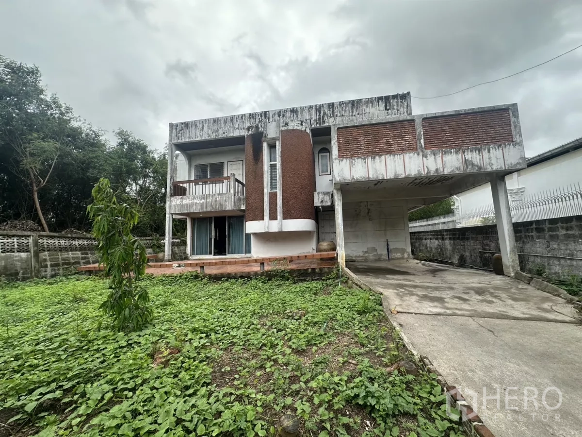 บ้าน ขายในPhra Khanong, Bangkok - มุมมองด้านหน้าบ้านเดี่ยว ทางรถยาว พร้อมเฉลียงยกระดับและสวนล้อมกำแพง ใกล้ BTS ปุณณวิถี