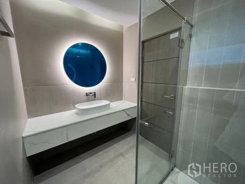 联排别墅 for rent in Phra Khanong, Bangkok - 现代浴室，圆形发光镜台盆与玻璃淋浴间。