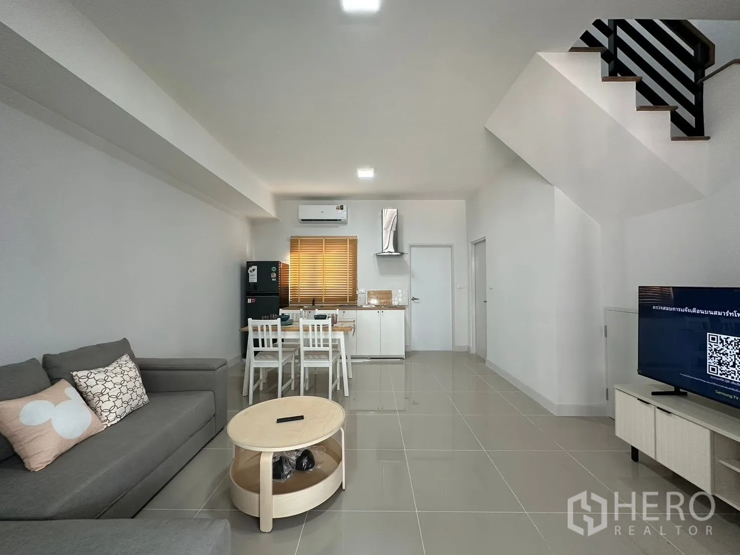ทาวน์เฮาส์ for rent in Bang Phli, Samut Prakan - ภาพกว้างพื้นที่นั่งเล่นโปร่งโล่ง มีชั้นวางทีวี บันได และครัวกะทัดรัด