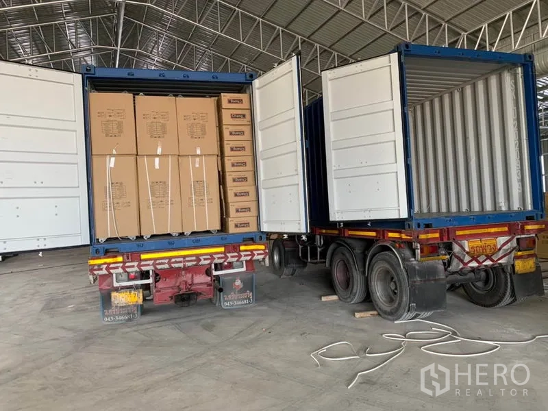 Warehouse for sale in Phra Nakhon Si Ayutthaya - Two container trucks loading inside the warehouse, demonstrating large access and height.