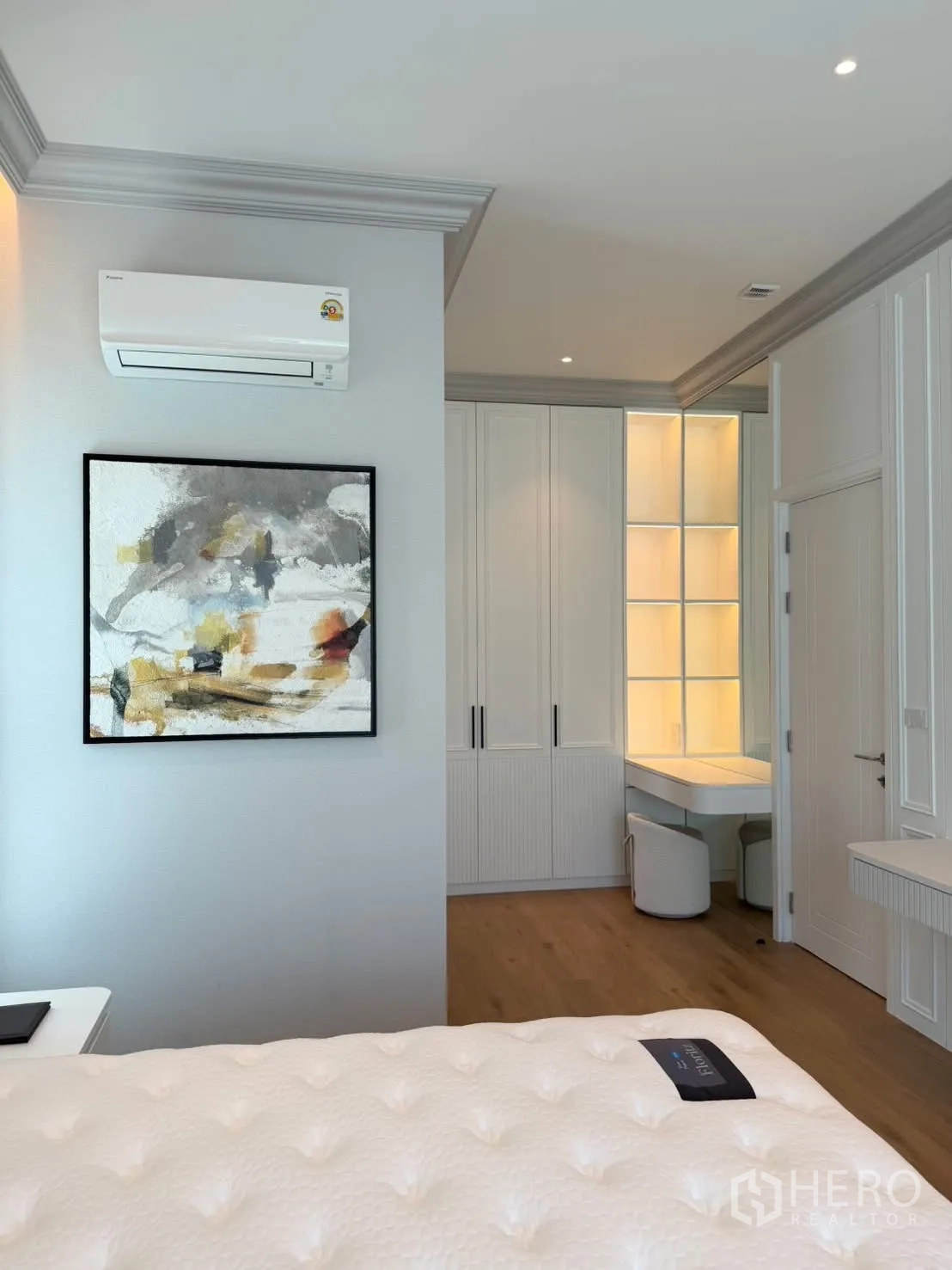 Detached House for rent in Saphan Sung, Bangkok - Bright bedroom corner with wall-mounted AC, abstract art, built-in wardrobe, and vanity.