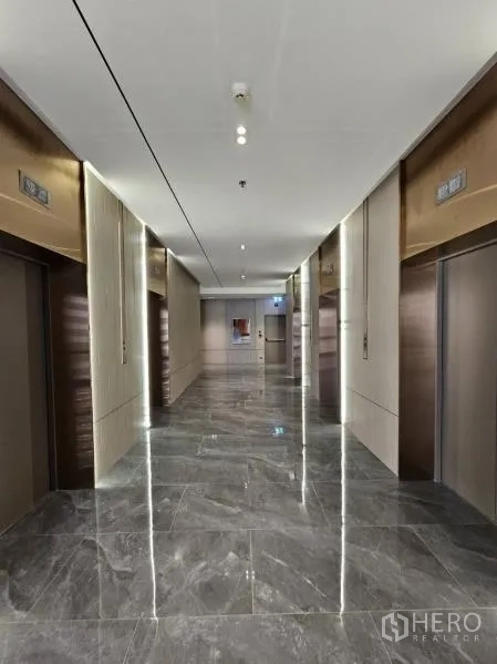办公空间 出租在Bang Rak, Bangkok - 现代电梯大堂，多部电梯，抛光石材地面与氛围照明。