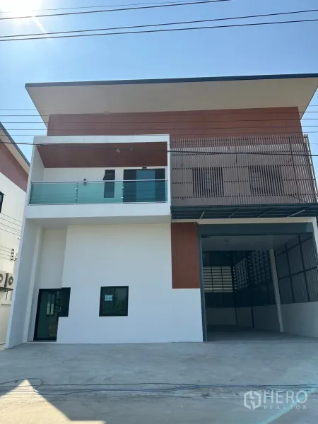Warehouse for rent or sale - Modern two‑storey warehouse facade with glass balcony and wide driveway.