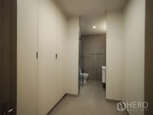 คอนโด ให้เช่าหรือขายในPathum Wan, Bangkok - โถงทางเดินตู้เสื้อผ้าบิลท์อินเชื่อมสู่ห้องน้ำที่มีฉากกั้นอาบน้ำกระจก