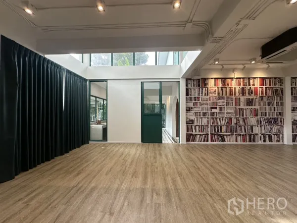 สำนักงานที่บ้าน ให้เช่าหรือขายในPhra Khanong, Bangkok - ห้องสตูดิโอกว้าง มีสกายไลท์ พื้นไม้ และผนังลายชั้นหนังสือ