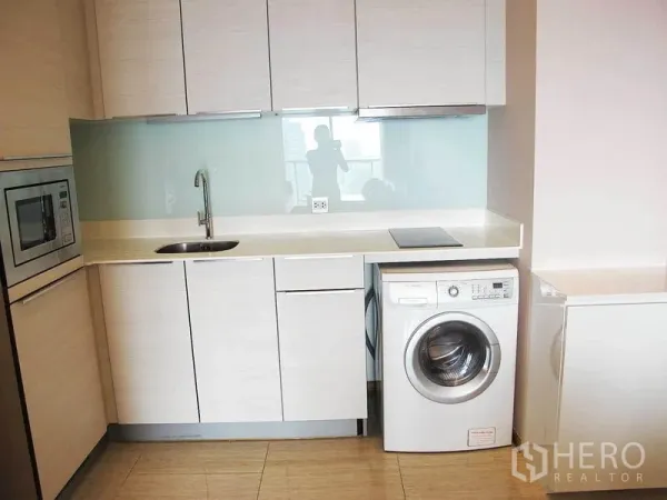 คอนโด ให้เช่าในWatthana, Bangkok - ครัวโทนไม้สว่าง มีไมโครเวฟ อ่างล้างจาน ฉากกระจก เตาไฟฟ้า และเครื่องซักผ้าฝาหน้า