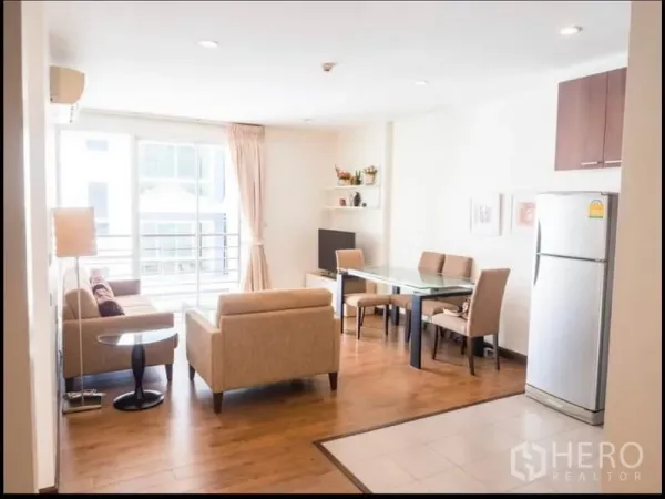 Condominium for rent or sale in Phra Khanong, Bangkok - Bright open-plan living and dining area with glass table, sofa set, and large windows in a Phra Khanong condo near BTS Punnawithi.