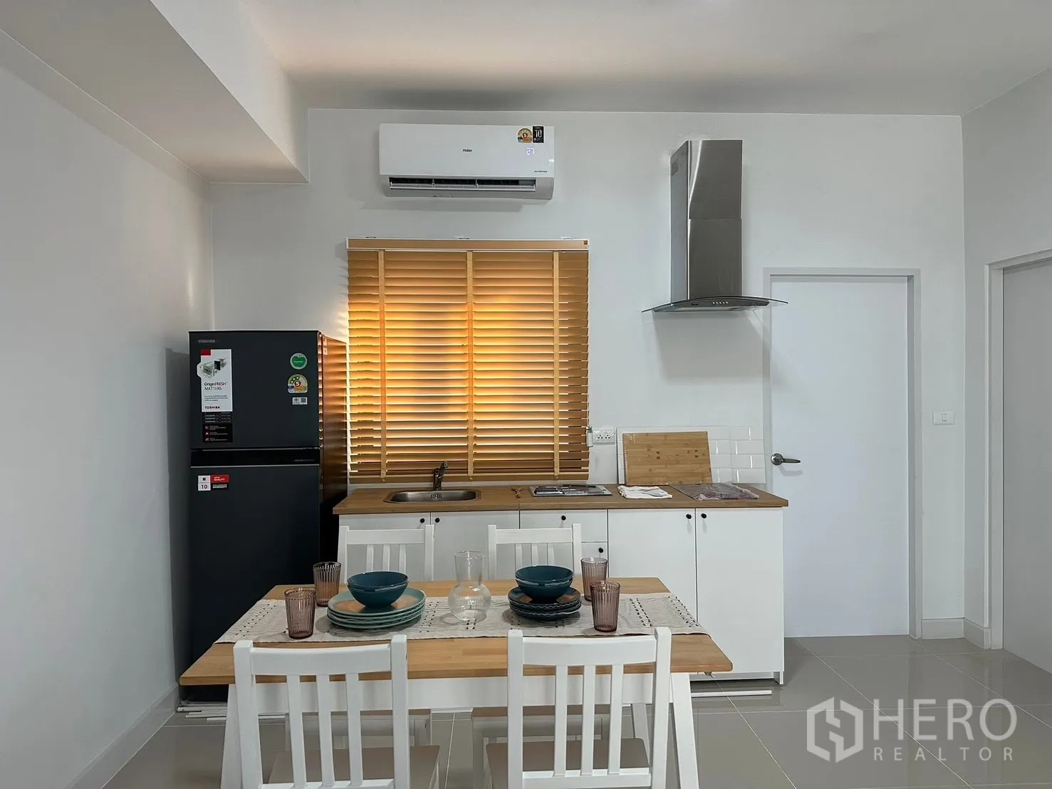 ทาวน์เฮาส์ for rent in Bang Phli, Samut Prakan - รายละเอียดครัว เคาน์เตอร์ขาวท็อปไม้ เครื่องดูดควัน ตู้เย็น และชุดโต๊ะอาหาร