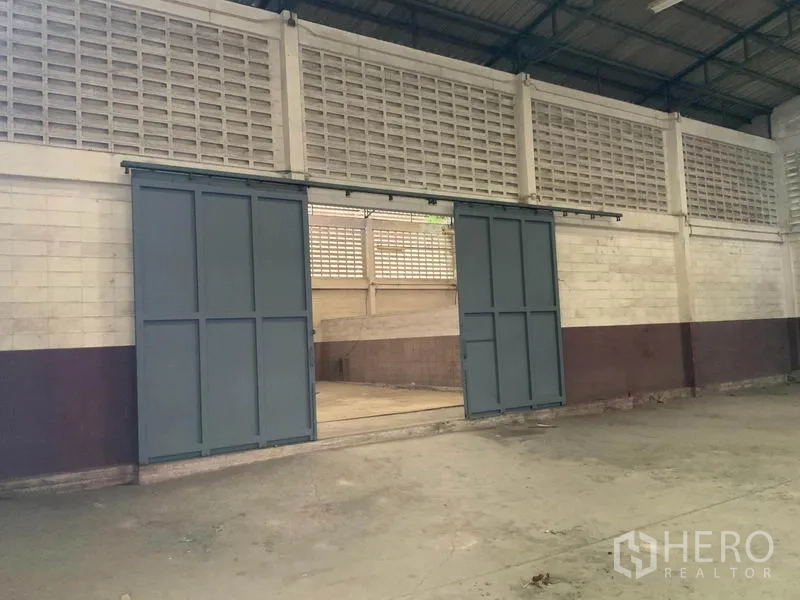 คลังสินค้า ให้เช่าในBang Kapi, Bangkok - ประตูบานเลื่อนเหล็กภายใน เปิดเชื่อมพื้นที่เก็บสินค้าอีกส่วน
