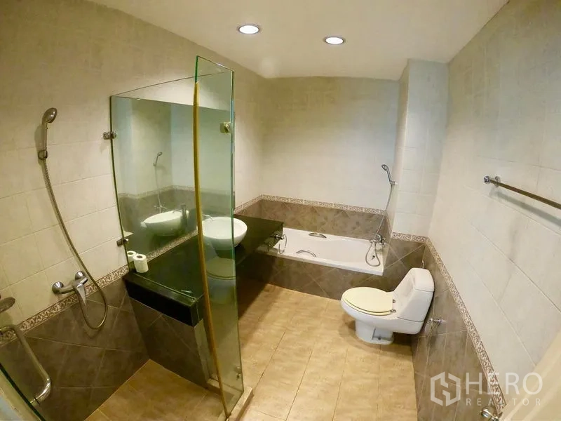 Townhouse for rent in Watthana, Bangkok - Bathroom with bathtub, separate glass shower, vessel sink and tiled walls.