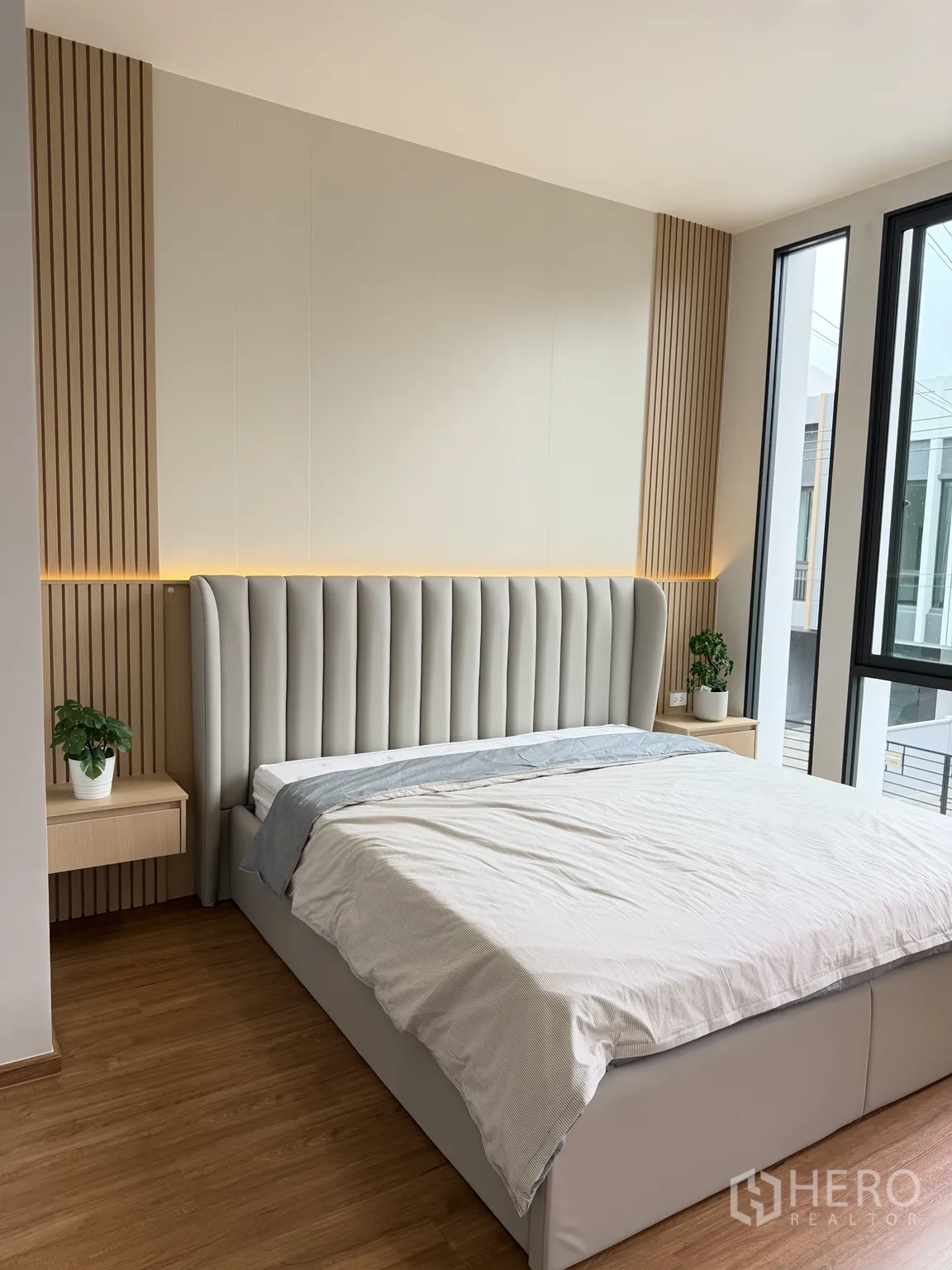 Townhouse for rent in Bang Phli, Samut Prakan - Master bedroom with padded headboard and large windows.