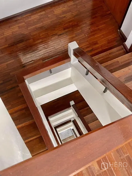 สำนักงานที่บ้าน ให้เช่าในKhlong Toei, Bangkok - มุมมองลงบันไดไม้จริงและช่องบันไดผนังสีขาว