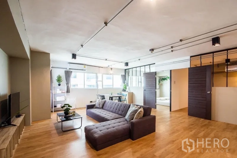 带办公室的家 出租在Phaya Thai, Bangkok - 宽敞开放式起居/办公区，转角沙发、餐桌与大窗采光。