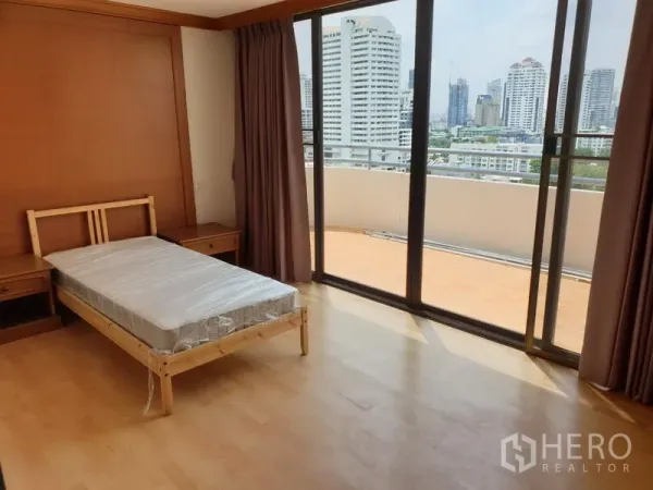 Condominium for rent in Watthana, Bangkok - Bedroom with single bed opening to a large terrace and skyline city views through floor-to-ceiling glass.