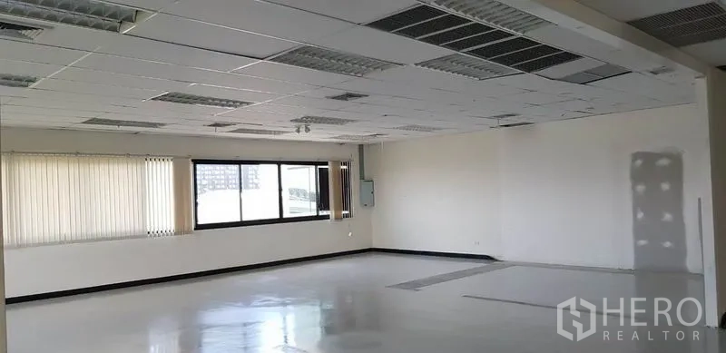 办公空间 出租在Khlong Toei, Bangkok - 开放工作区，大窗、吊顶空调出风口与白色墙面。