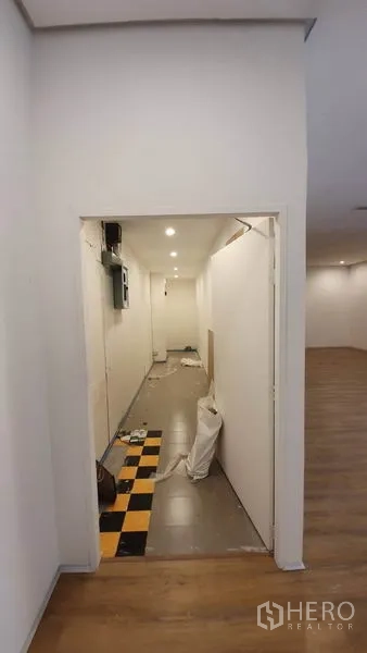 零售空间 出租在Khlong Toei, Bangkok - 后勤走廊/储物区，带设备与黑黄格地砖门槛。