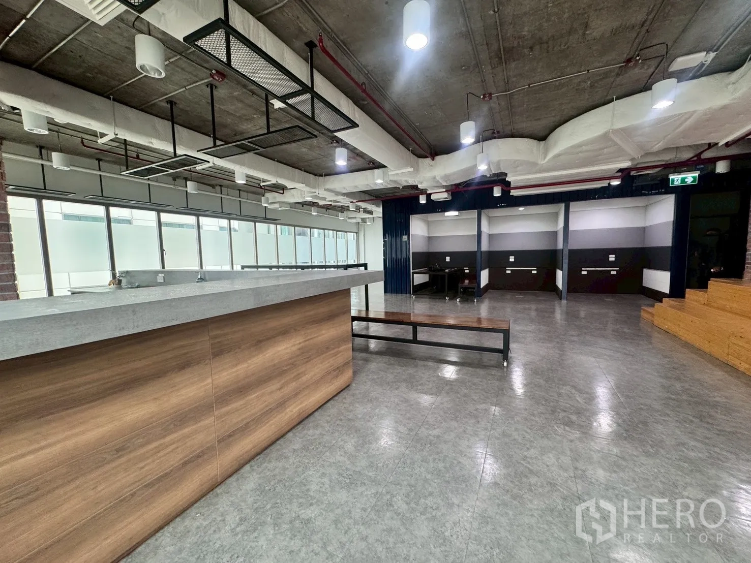 办公室 for rent in Watthana, Bangkok - 茶水吧台配工业风灯具与长凳座位。
