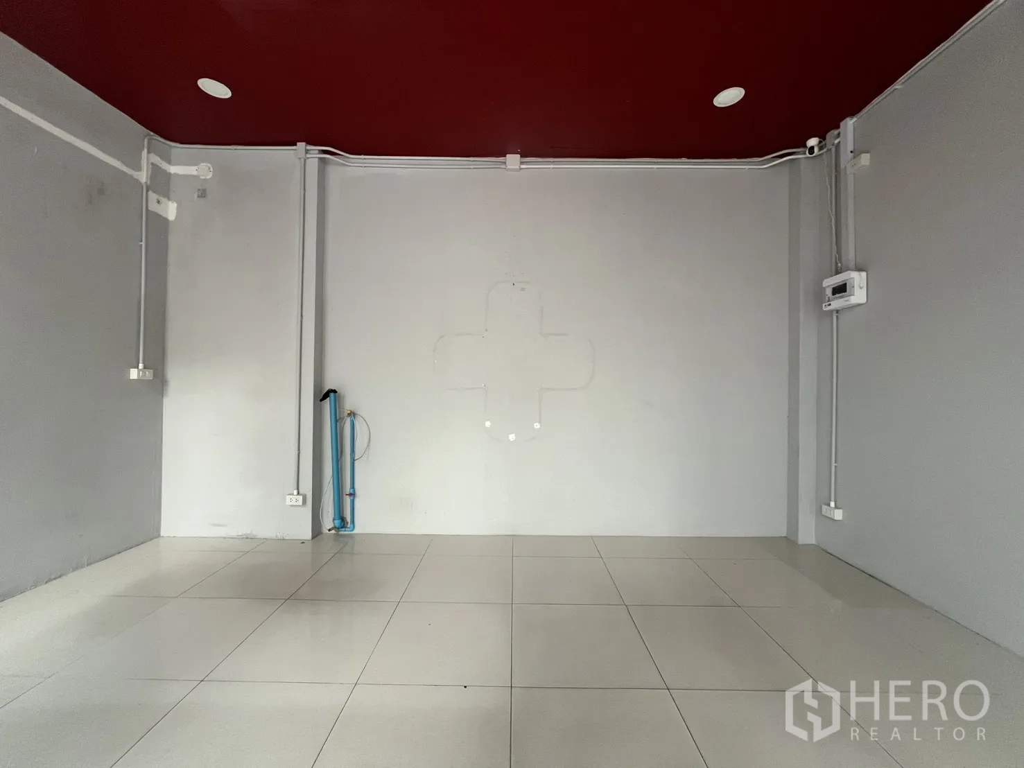 零售空间 for rent in Watthana, Bangkok - 白色地砖开放销售区，酒红色天花与电源插座，适合二次装修。