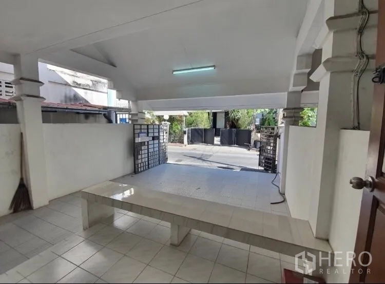 Townhouse for rent in Watthana, Bangkok - Covered carport and front porch facing a quiet residential lane.