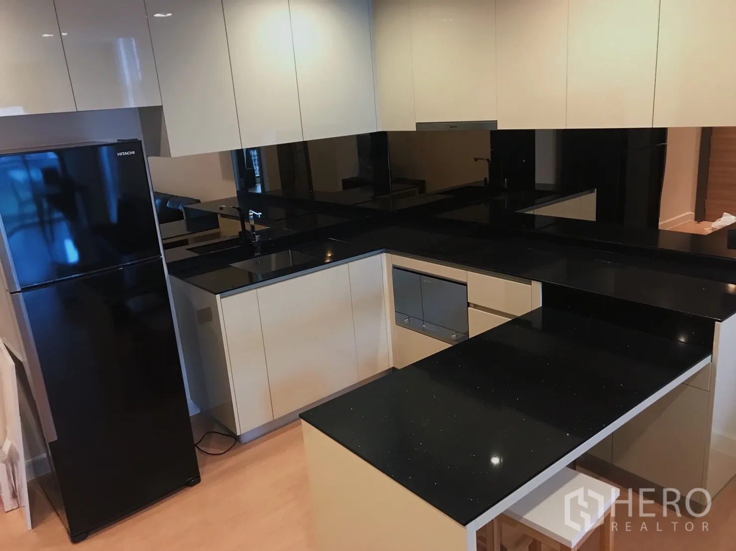 公寓 出租或出售在Bang Rak, Bangkok - 现代U型厨房，亮面橱柜与黑色石材台面