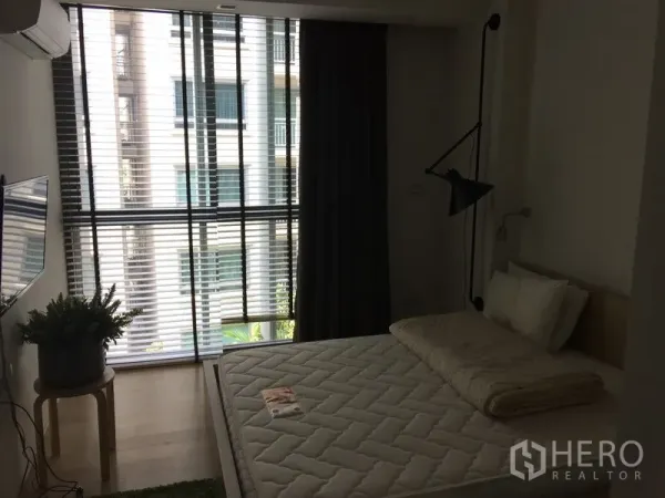 公寓 出租在Watthana, Bangkok - 舒适卧室，大片百叶与遮光帘，壁挂电视与大床。