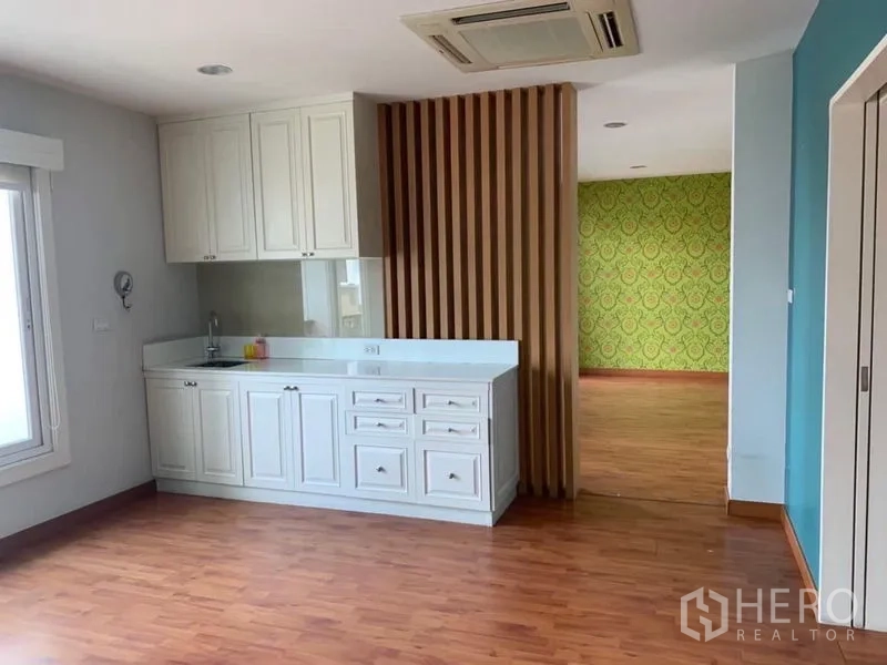 สำนักงานที่บ้าน ให้เช่าในPhra Pradaeng, Samut Prakan - มุมแพนทรีชั้นบน ตู้บิลท์อินสีขาวพร้อมอ่างล้างจาน กั้นด้วยซี่ไม้และพื้นไม้