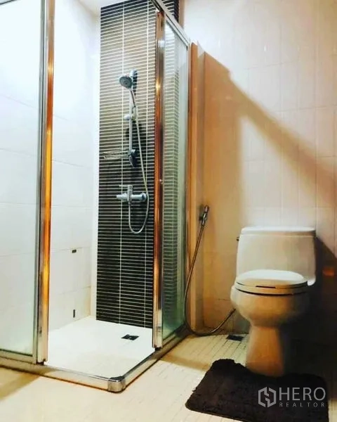 公寓 出租在Watthana, Bangkok - 现代浴室，玻璃淋浴间、手持花洒与坐便器。