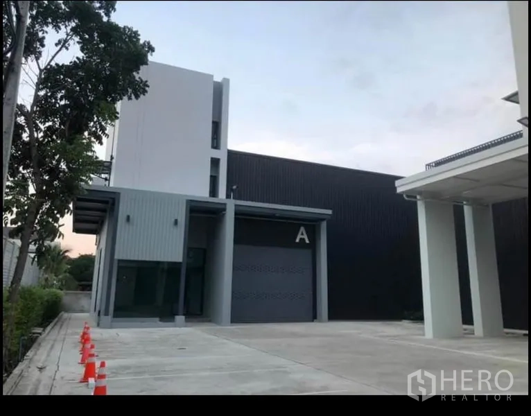 Office Space for rent in Wang Thonglang, Bangkok - Exterior view of office block with roller door, wide driveway and safety cones.