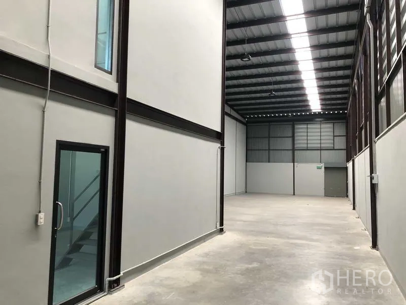 货栈 出租在Bang Phli, Samut Prakan - 高挑仓库内部，钢结构屋顶、天窗带与平整混凝土地面。