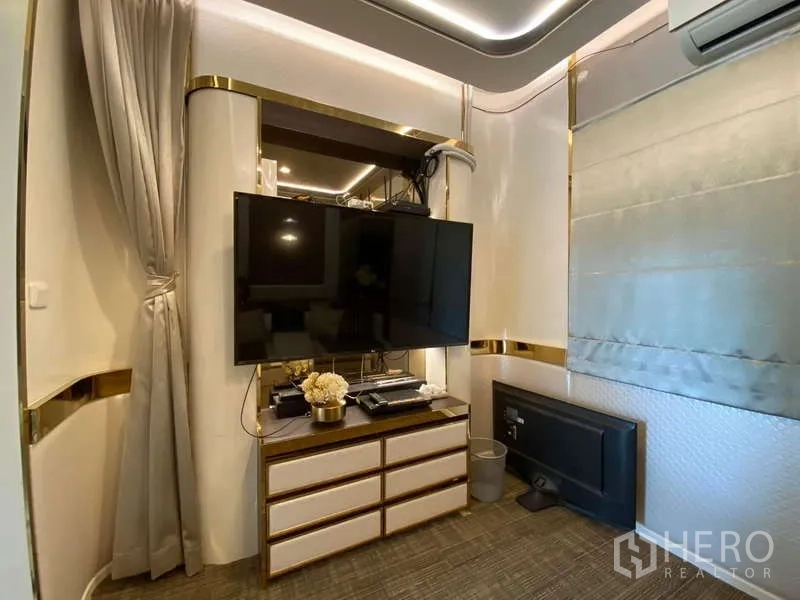 บ้าน ให้เช่าหรือขายในBueng Kum, Bangkok - มุมดูทีวีติดผนัง พร้อมตู้บิลท์อินและตกแต่งคาดสีทอง