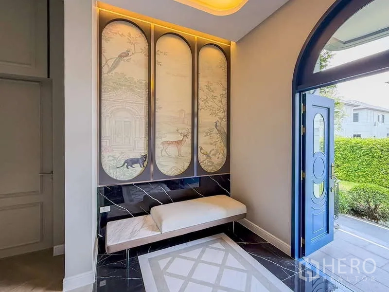 Detached House for rent or sale in Bang Kapi, Bangkok - Elegant foyer with blue front door, marble bench and decorative wall panels.