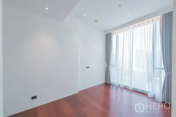 公寓 出售在Watthana, Bangkok - 转角卧室，落地窗、灰色窗帘与白色墙面。