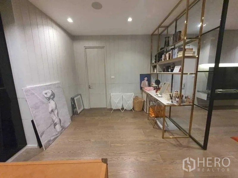 Detached House for rent or sale in Prawet, Bangkok - Multipurpose room with brass-framed shelving and wood floors.